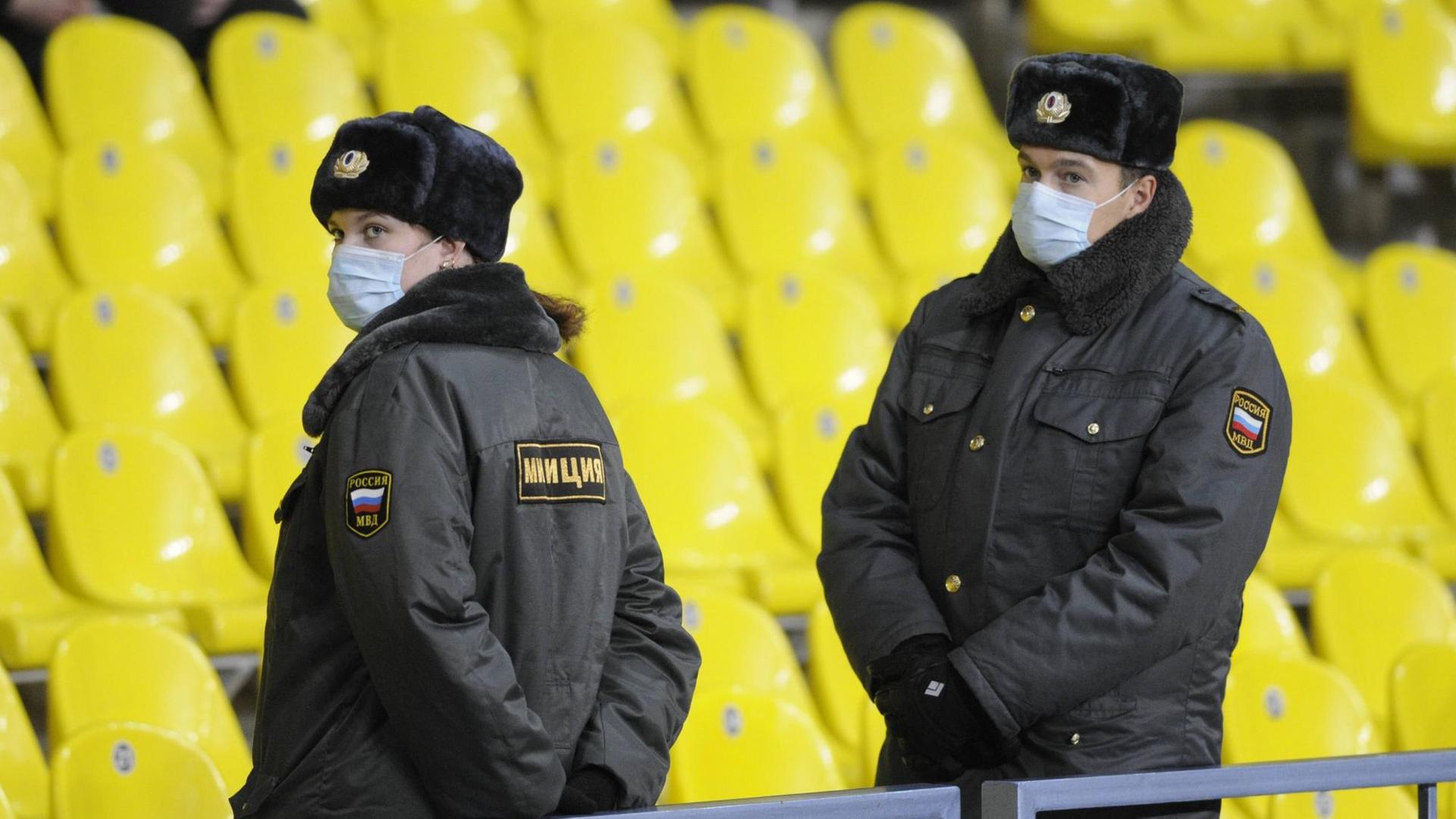 Sicherheitskräfte mit Mundschutz bei einem Fußballspiel in Moskau