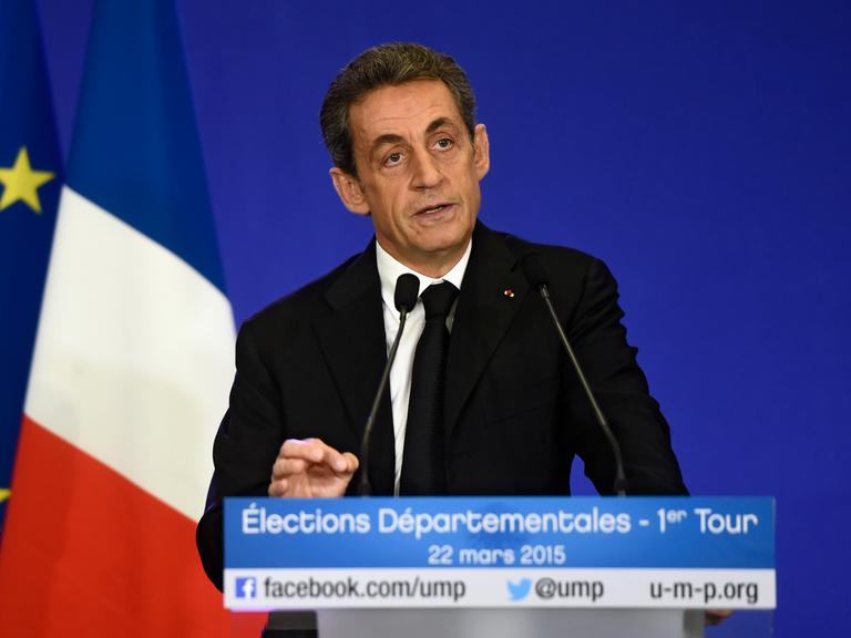 Nicolas Sarcozy steht hinter einem Rednerpult, dahinter eine französische und eine EU-Flagge.