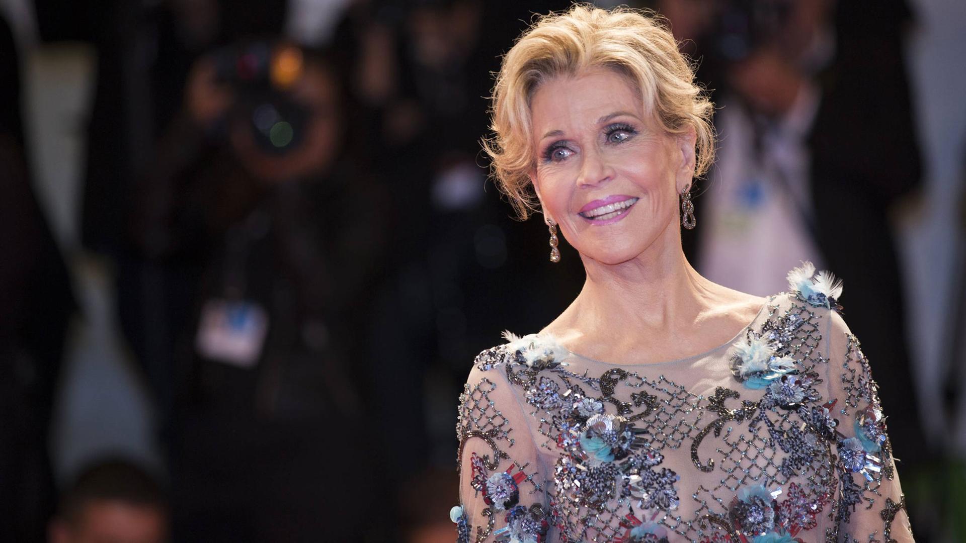 Jane Fonda posiert für Fotografen auf dem roten Teppich.