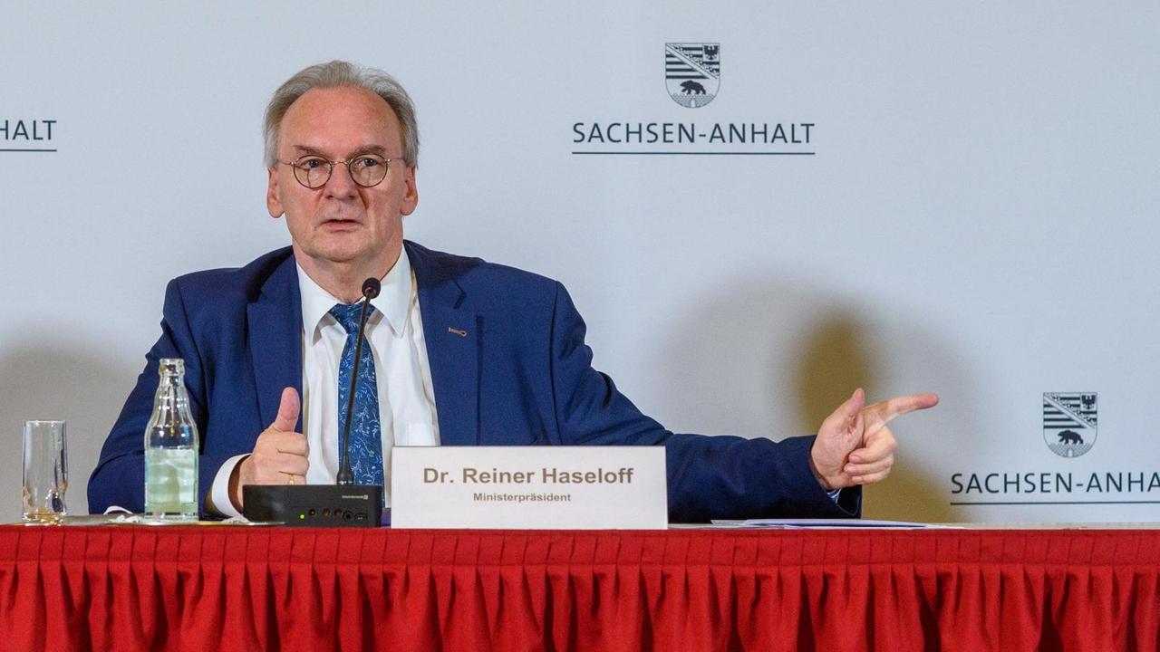 Reiner Haseloff (CDU), Ministerpräsident des Landes Sachsen-Anhalt, an einem Tisch bei einer Pressekonferenz
