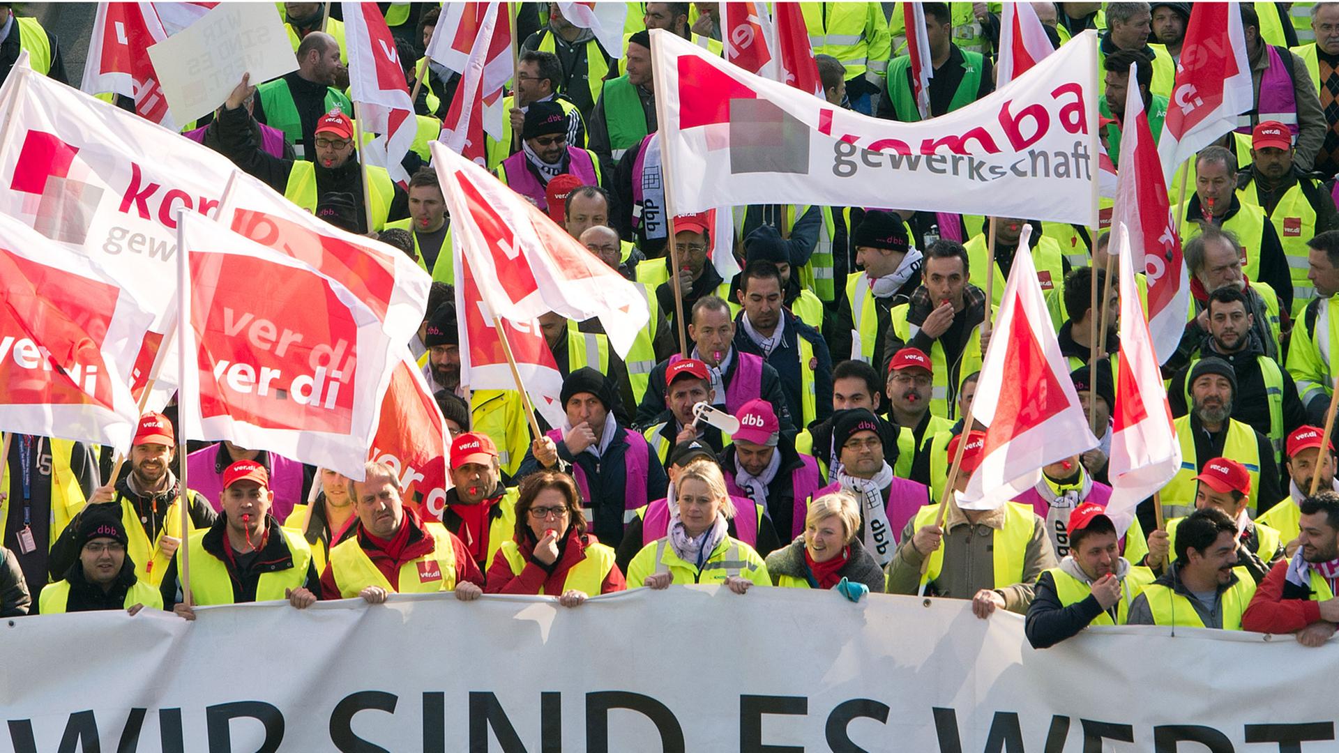 Mitglieder verschiedener Gewerkschaften protestieren vor dem Flughafen in Frankfurt am Main (Hessen) und halten dabei ein Banner mit der Aufschrift "Wir sind es Wert"