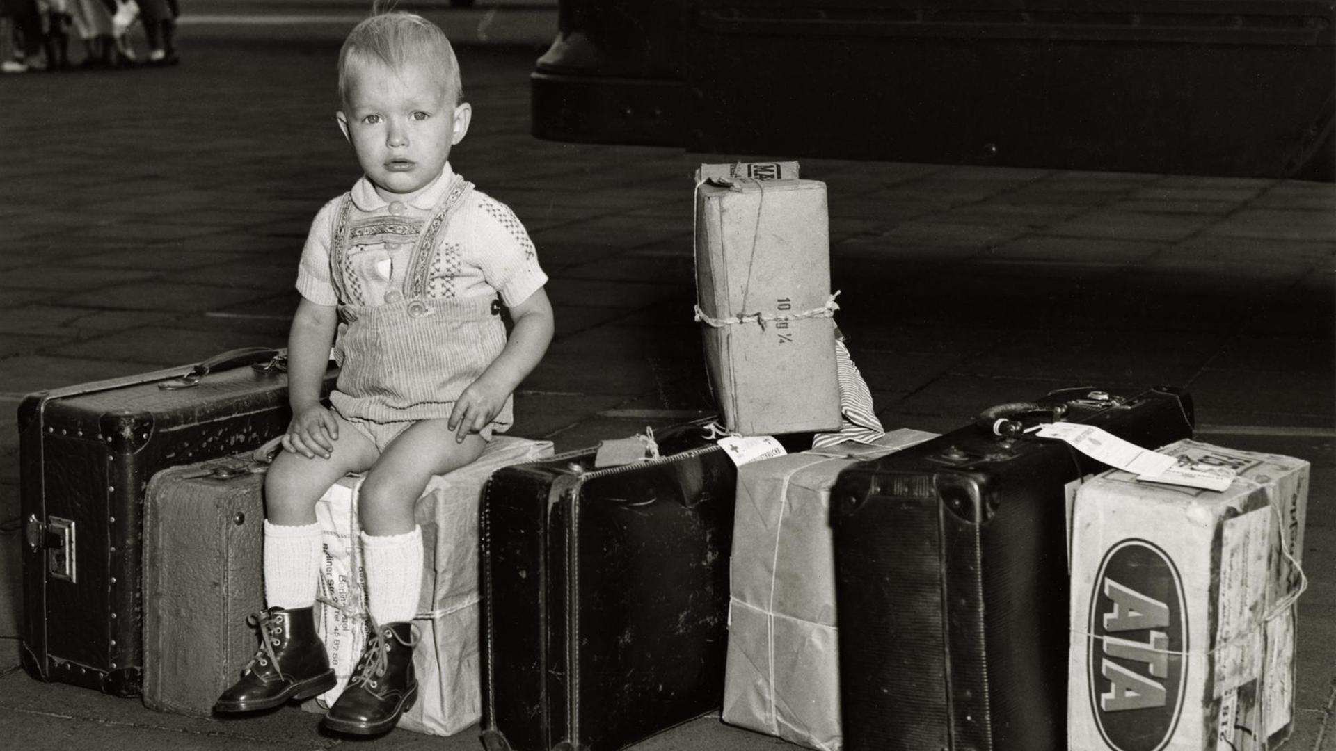 Symbolbild Kinderverschickung. Verschickung von Flüchtlingskindern aus Berlin zu einem Ferienaufenthalt nach Westdeutschland. Ein kleiner Junge wartet auf dem Flugfeld des Flughafens Tempelhof, 17. August 1953.