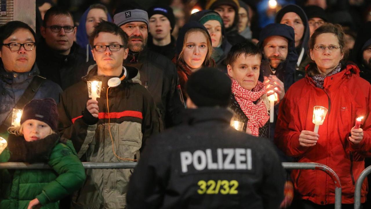 Gegner des islamkritischen Legida-Bündnisses demonstrieren am 11.01.2016 in Leipzig (Sachsen) mit Kerzen in der Hand.