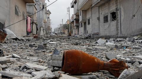 Eine Mörsergranate liegt in einer Straße in Kobane zwischen den Trümmern.