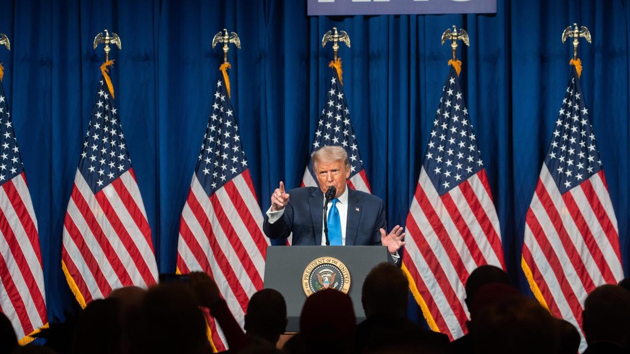 US-Präsident Trump hält eine Rede, hinter ihm stehen mehrere US-Flaggen.