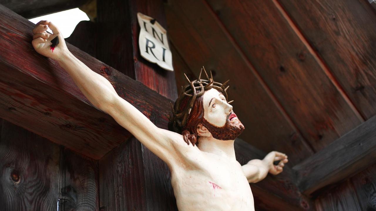 Eine Jesusfigur an einem Wegkreuz in Tirol, Österreich