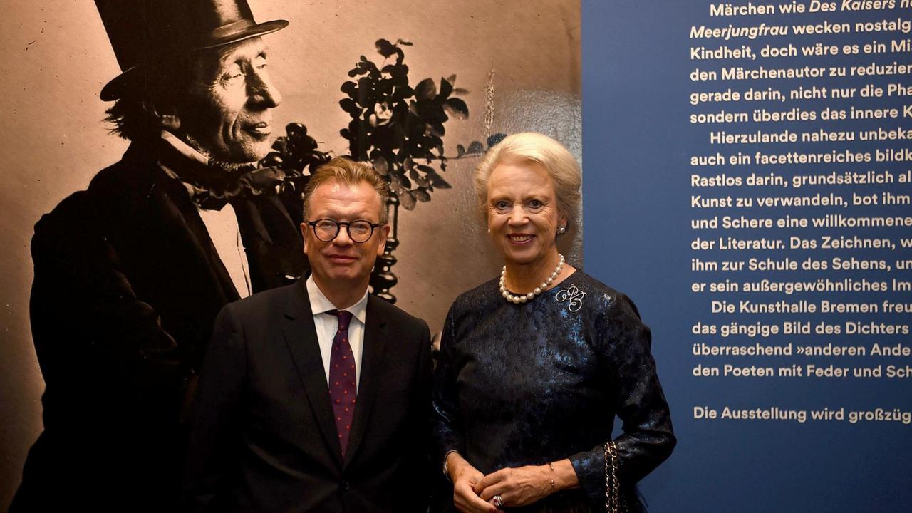 Prinzessin Benedikte zu Dänemark und Christoph Grunenberg, Direktor der Kunsthalle Bremen, stehen bei einem Fototermin anlässlich der Ausstellungseröffnung "Hans Christian Andersen" vor einem Bild des Dichters