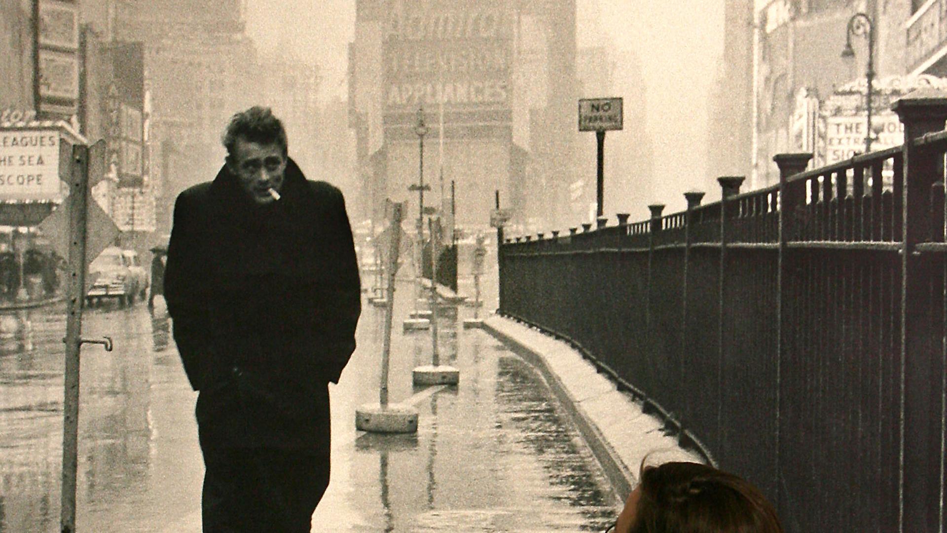 Eine Frau blickt auf ein Schwarz-Weiß-Bild mit James Dean, der den Times Square entlang geht.