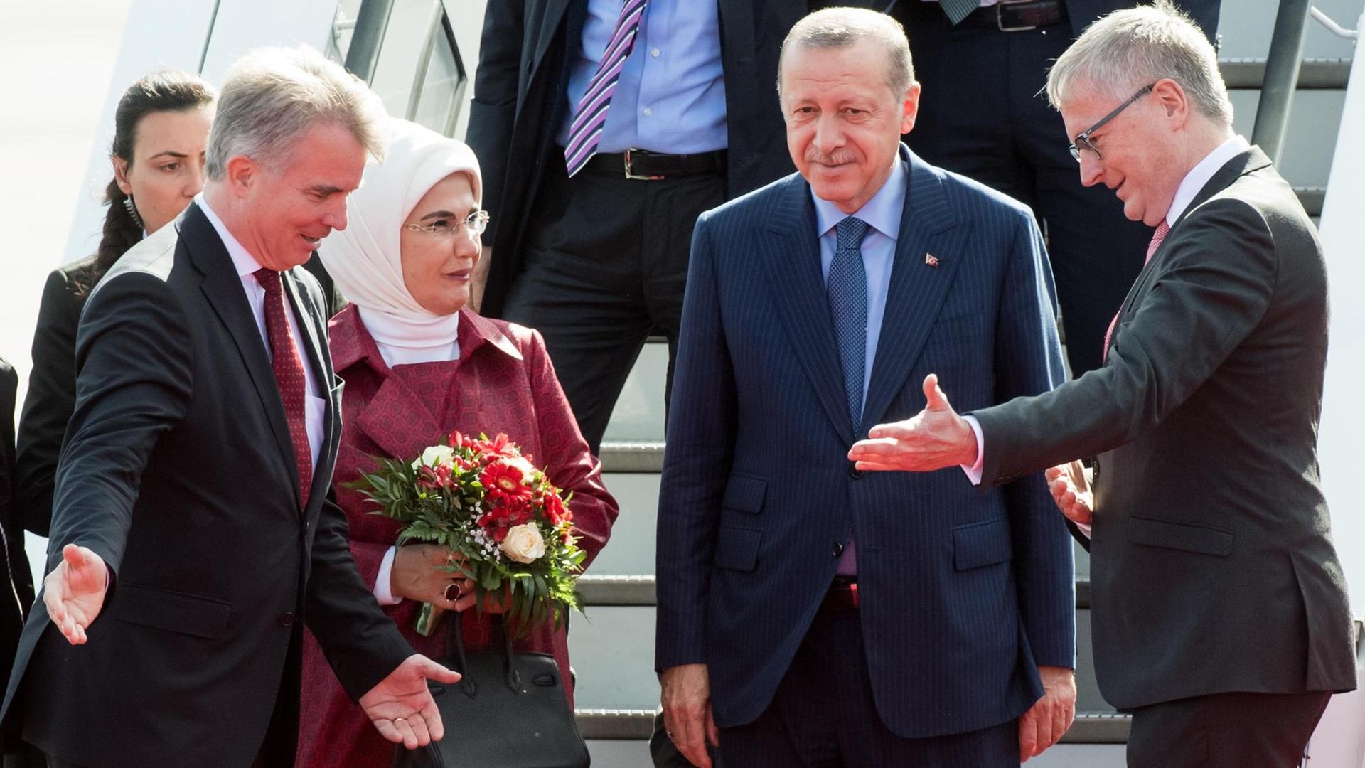 Recep Tayyip Erdogan (2.v.r), Präsident der Türkei, und seine Frau Emine Erdogan kommen auf dem militärischen Teil des Flughafen Tegel an und werden vom Chef des Protokolls, Konrad Arz von Straussenburg (l), und Stephan Steinlein (r), Chef des Bundespräsidialamts, begrüßt.