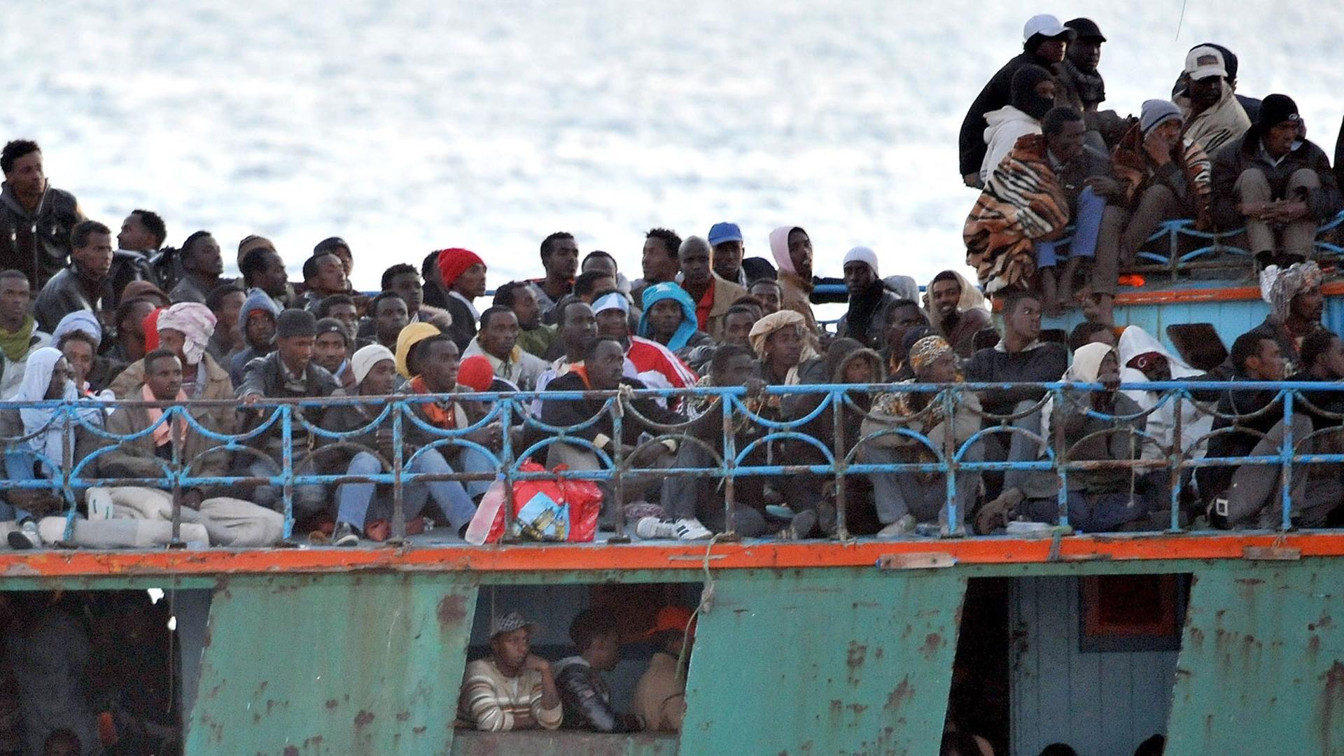 Ein überfülltes Boot mit Flüchtlingen aus Afrika schwimmt vor der italienischen Insel Lampedusa.