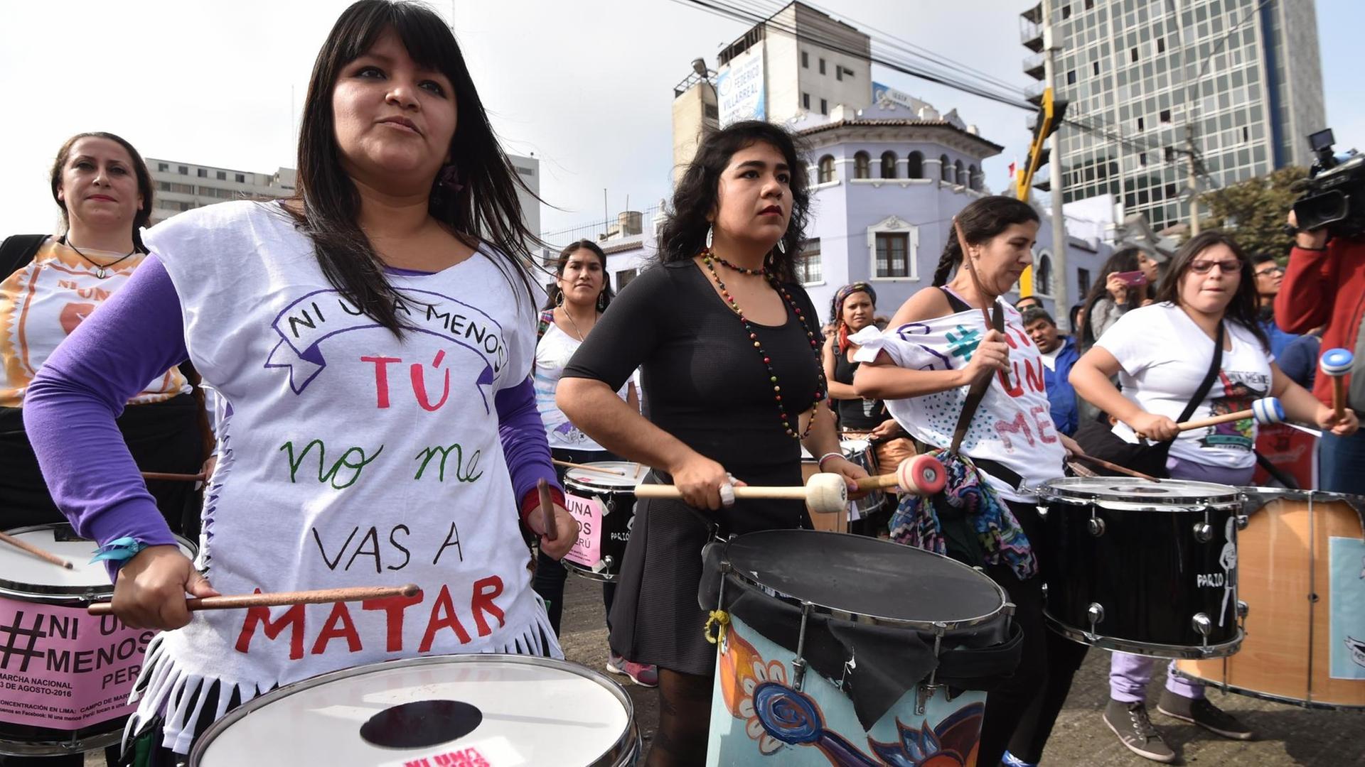 Teilnehmerinnen eines Protestmarsches gegen Gewalt gegen Frauen laufen trommelnd durch Perus Hauptstadt Lima.