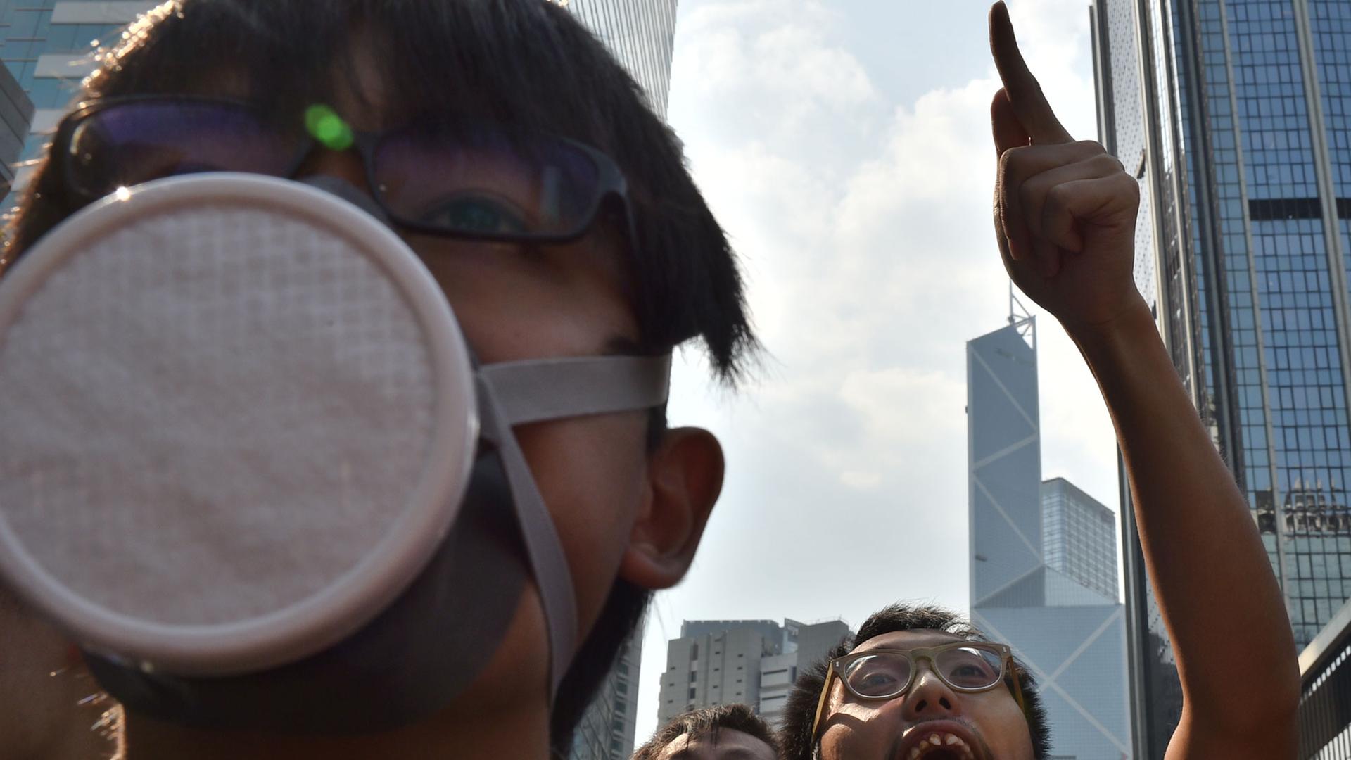 Ein maskierter Mann und Demonstranten in der Innenstadt von Hongkong.