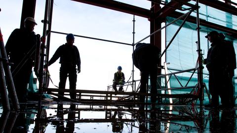 Gerüstbauer arbeiten auf einer Baustelle.