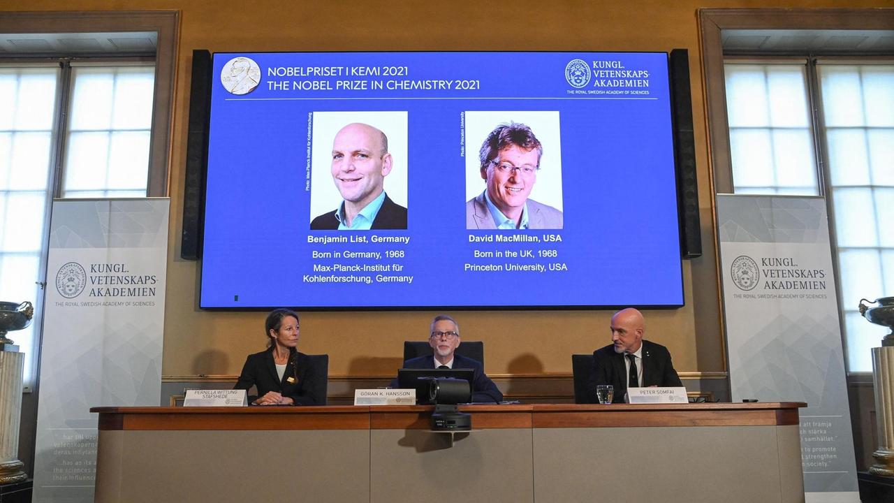 Der Bildschirm mit den Bildern der Chemie-Nobelpreisträger Benjamin List und David Macmillan. Der Bildschirm mit den Bildern der Chemie-Nobelpreisträger Benjamin List und David Macmillan.