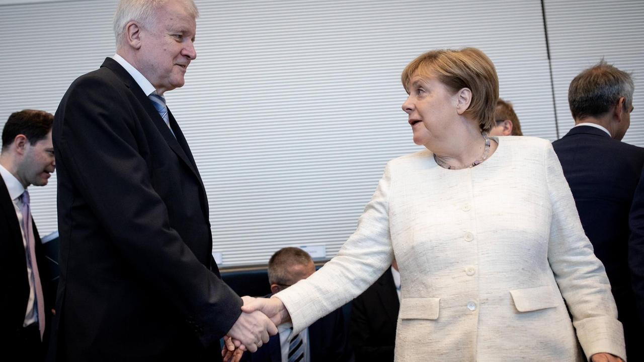Horst Seehofer (CSU), Bundesminister des Innern, für Bau und Heimat, und Bundeskanzlerin Angela Merkel (CDU) geben sich zu Beginn der Fraktionssitzung der CDU/CSU Fraktion im Bundestag die Hand. 