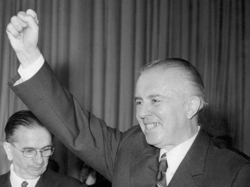 Ein SchwarzWeiß-Foto zeigt den albanischen Diktator Enver Hodscha, wie er beim 7. Kongress der P.T.A im Dezember 1976 kämpferisch die Faust in die Höhe streckt