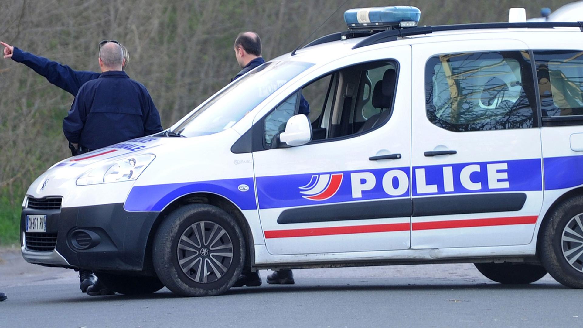 Ein französischer Polizist steht am 15.04.2015 neben einem Polizeiauto.