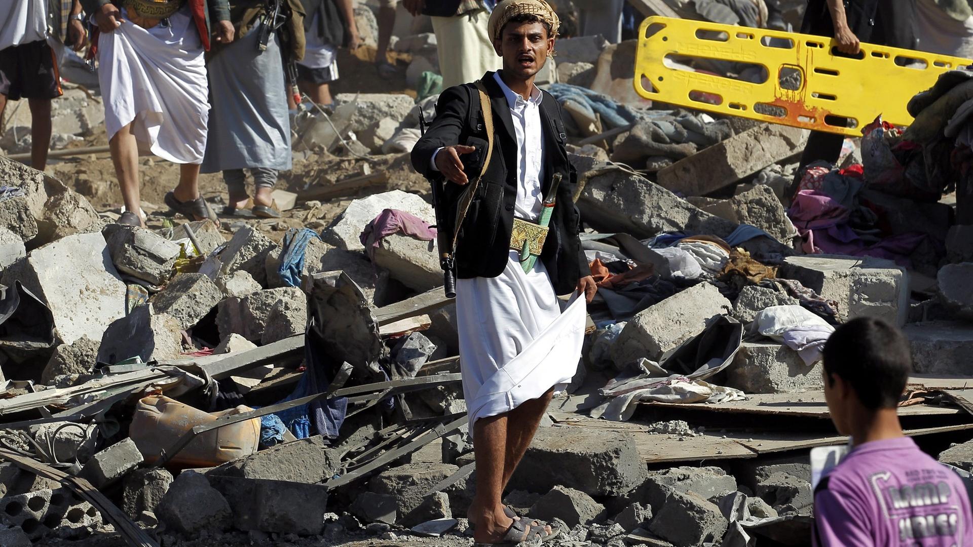 Menschen laufen nach einem saudi-arabischen Luftangriff über Schutt und Trümmer.