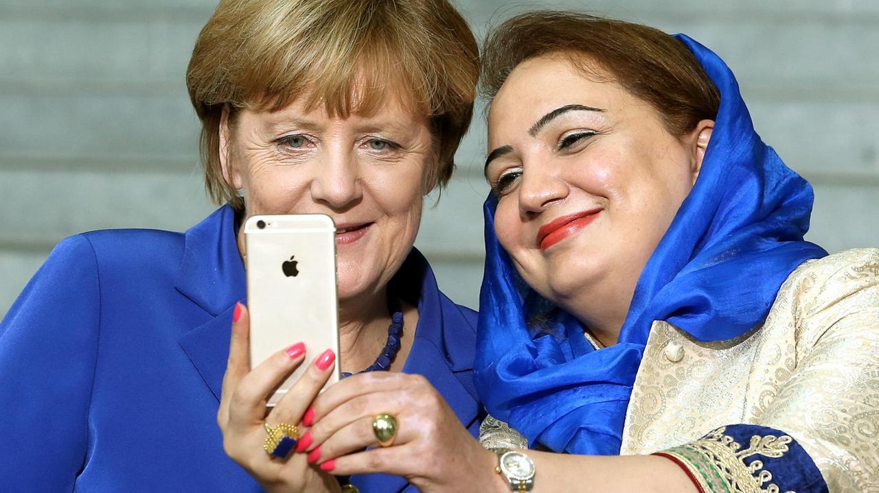 Bundeskanzlerin Angela Merkel und die afghanische Politikerin Schukria Barakzai machen ein Selfie; Aufnahme vom 16. September 2015