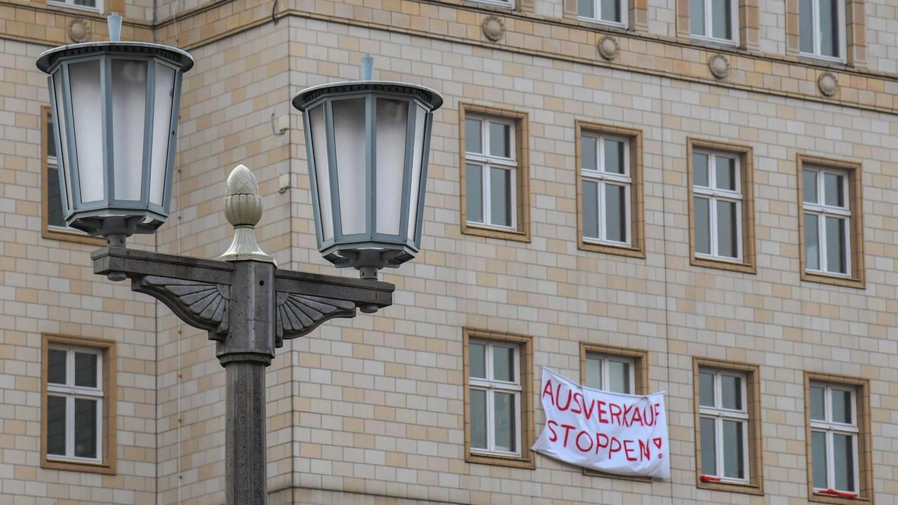 Fassade eines Hauses im Zuckerbäcker-Stils in Berlin-Friedrichshain. An einem Fenster hängt das Plakat "Ausverkauf stoppen".