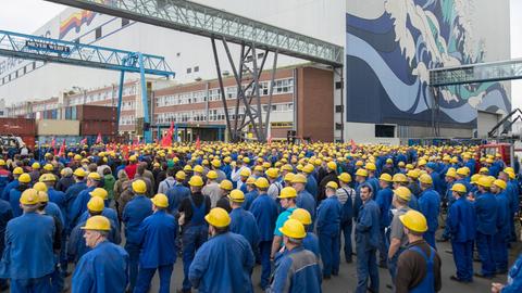 Arbeiter der Meyer-Werft bei einer Betriebsversammlung unter freiem Himmel.