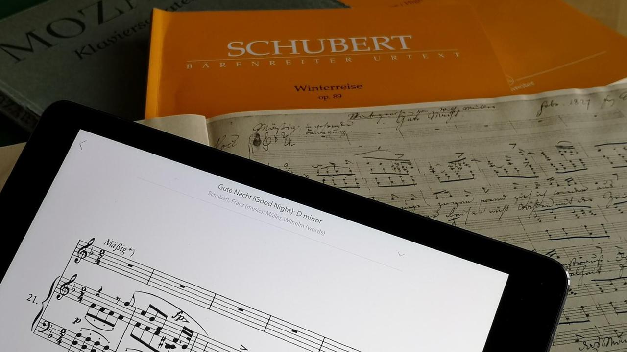 Noten von Franz Schuberts "Winterreise", op. 89 als Faksimile, Urtext-Ausgabe sowie auf einem Tablet