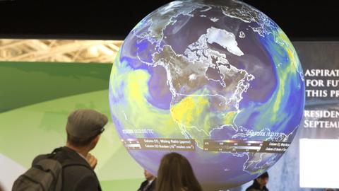 Menschen sehen sich den Globus bei der Klimakonferenz in Paris an.