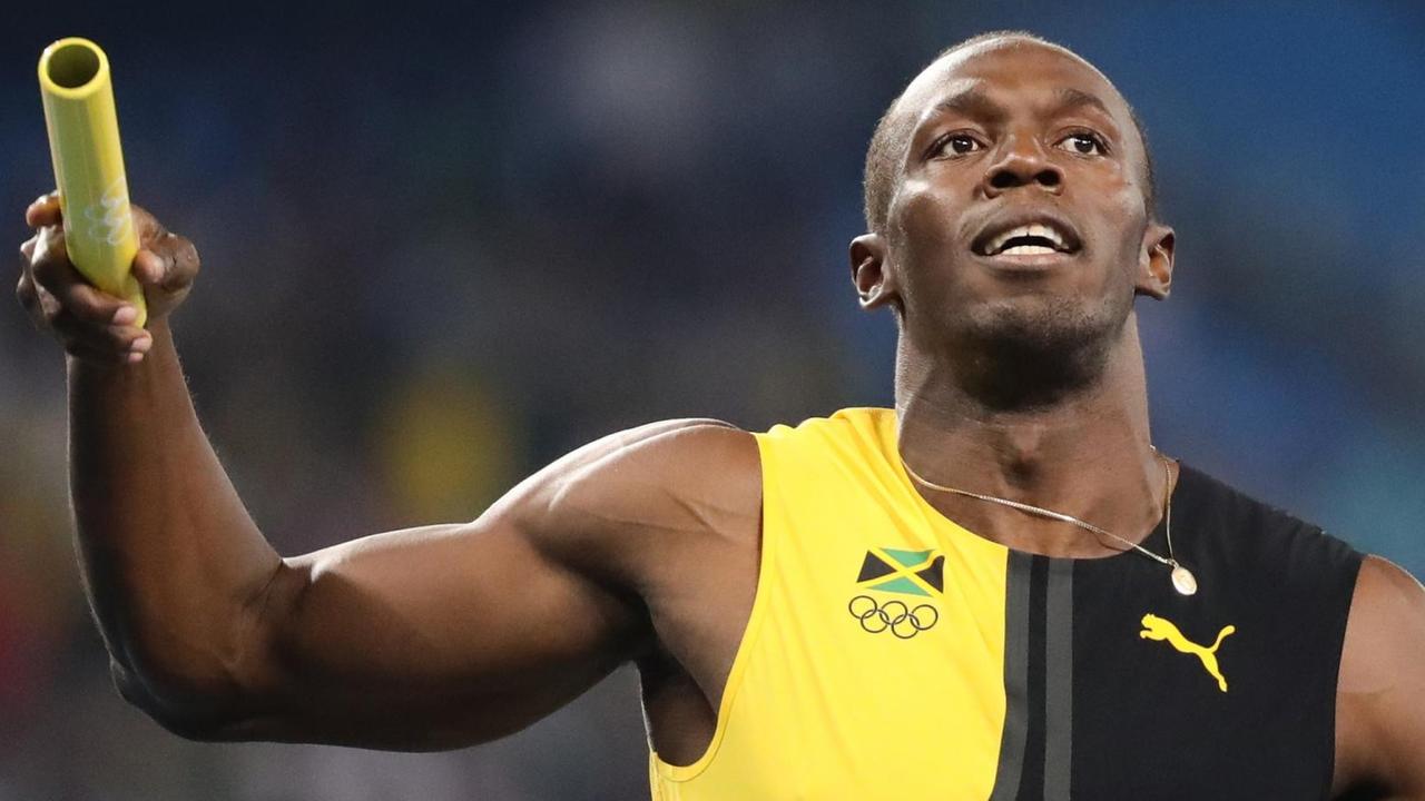 Der Läufer Usain Bolt hält einen Staffel-Stab in der Hand.