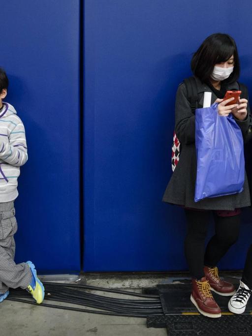 Vier Kinder vertreiben sich die Zeit mit Spielen auf ihren Mobiltelefonen.