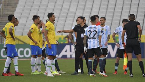 Argentina's (R) and Brazil's players are seen after employees of the National Health Surveillance Agency (Anvisa) entered to the field during the South American qualification football match for the FIFA World Cup Qatar 2022 between Brazil and Argentina at the Neo Quimica Arena, also known as Corinthians Arena, in Sao Paulo, Brazil, on September 5, 2021. - Brazil's World Cup qualifying clash between Brazil and Argentina was halted shortly after kick-off on Sunday as controversy over Covid-19 protocols erupted. (Photo by NELSON ALMEIDA / AFP)