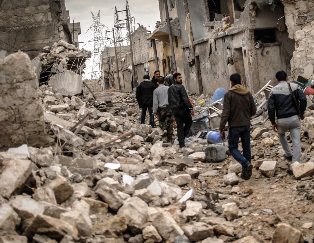 Rebellen der Freien Syrischen Armee (FSA) streifen am 07.02.2013 durch das zerstörte Sheik Saaid, einen Stadtteil von Aleppo, der ihnen als Ausgangspunkt im Kampf um eine Zementfabrik diente.