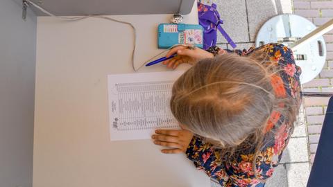 Ein elfjähriges Mädchen sitzt bei der U18-Europawahl 2019 in einer Wahlkabine in Brandenburg.