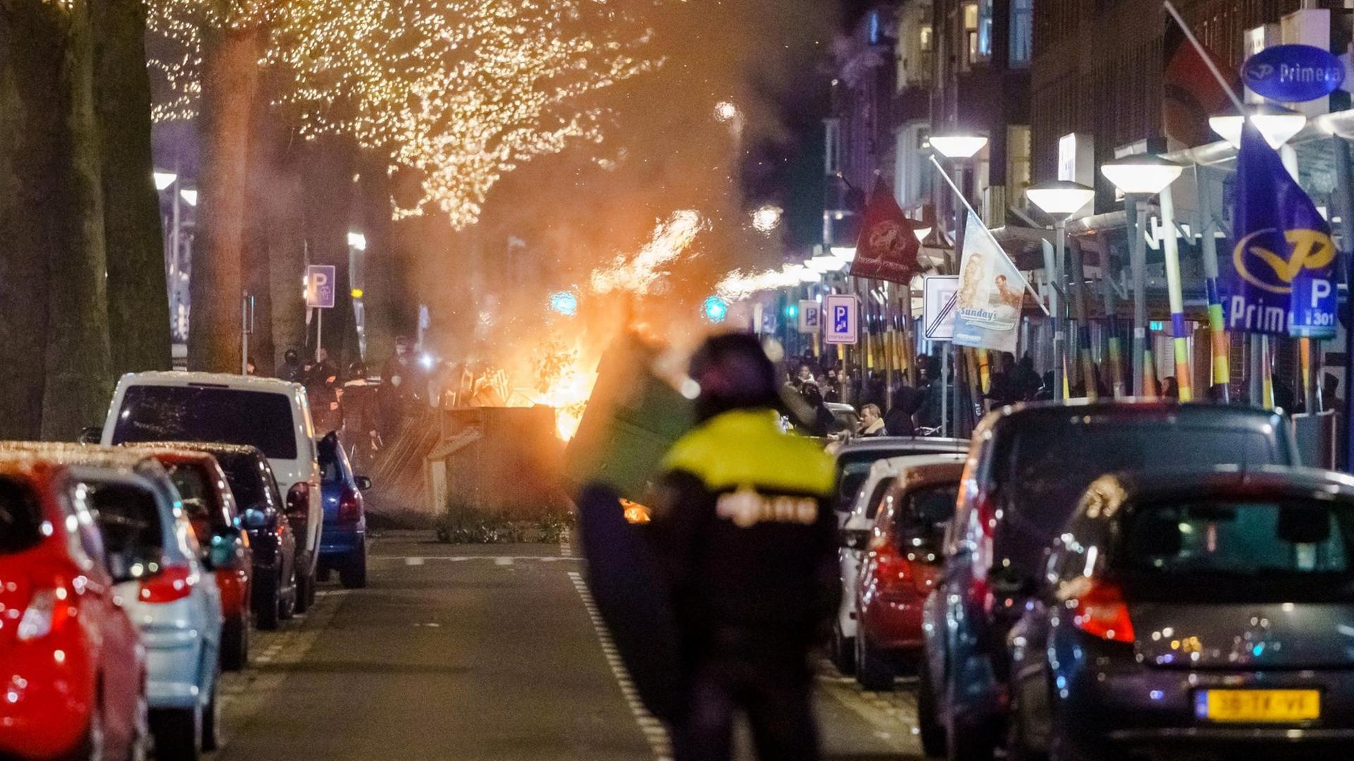 Randalierer haben eine Straße blockiert, es brennt ein Feuer.