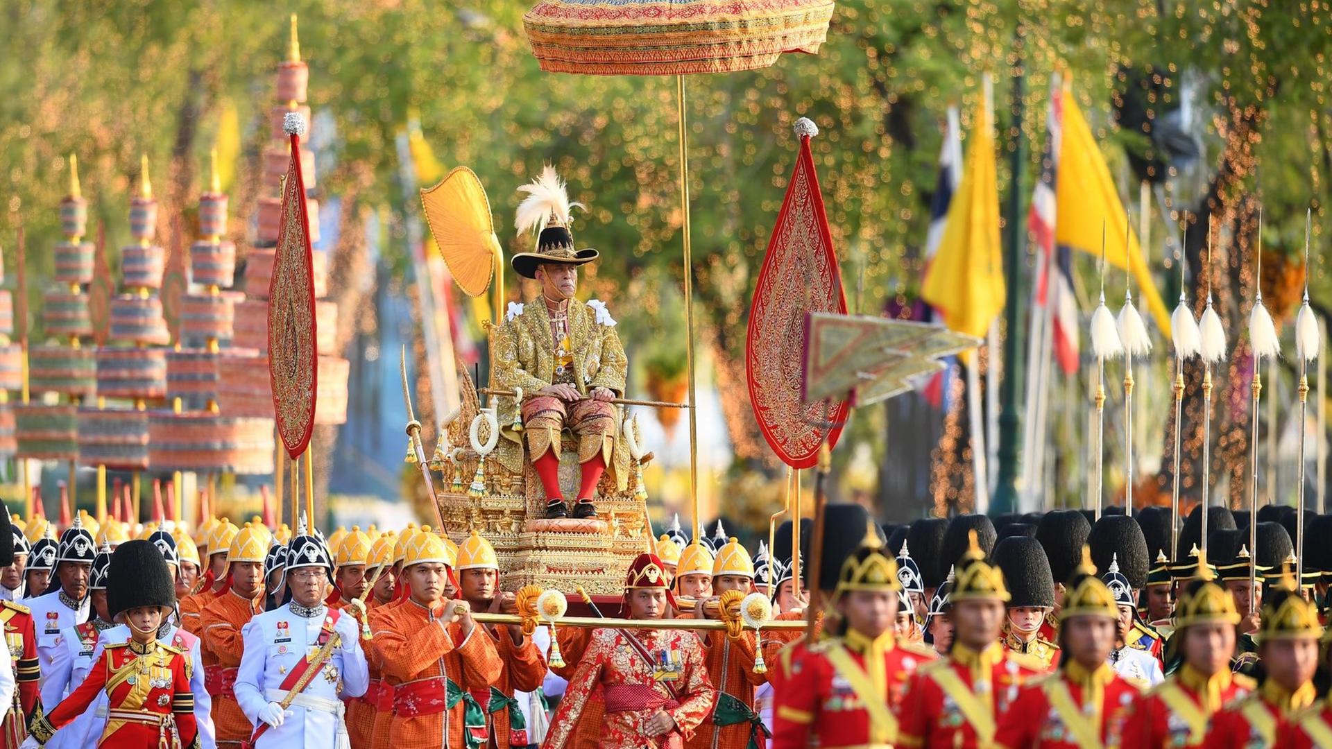 Thailands König Maha Vajiralongkorn wird in einer Prozession durch Bangkok getragen