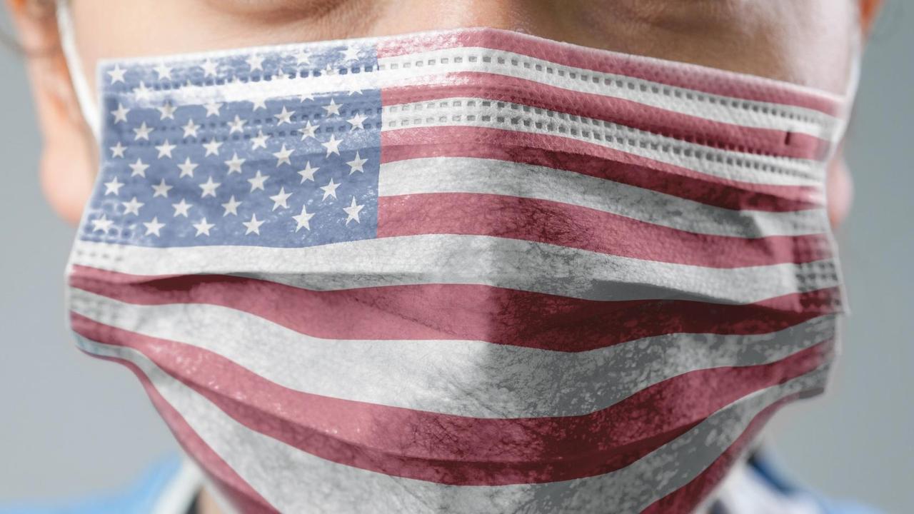 Ein Mensch trägt eine Maske, die mit der Flagge der USA bedruckt ist.