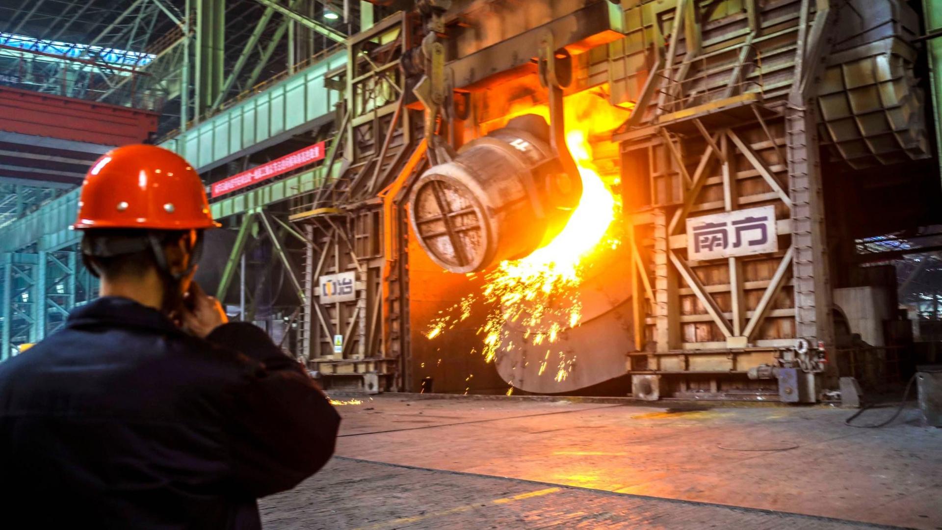 Ein chinesischer Arbeiter begutachtet die Stahlproduktion in einem Werk in Qingdao, China.