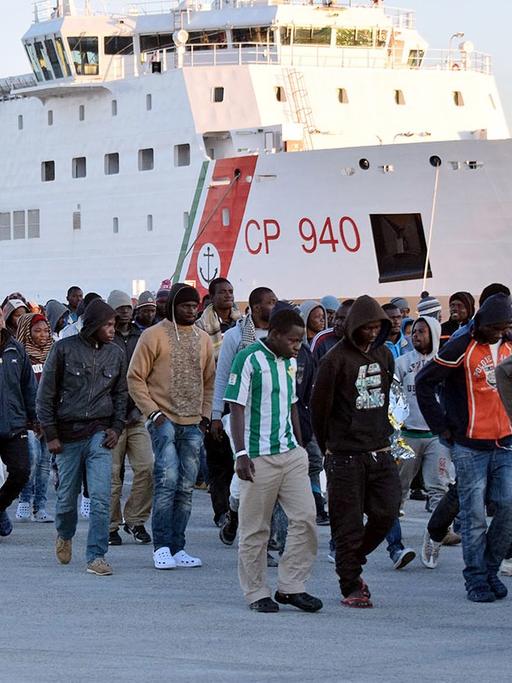 Flüchtlinge kommen auf Sizilien an, nachdem sie von der Küstenwache im Meer aufgegriffen wurden.