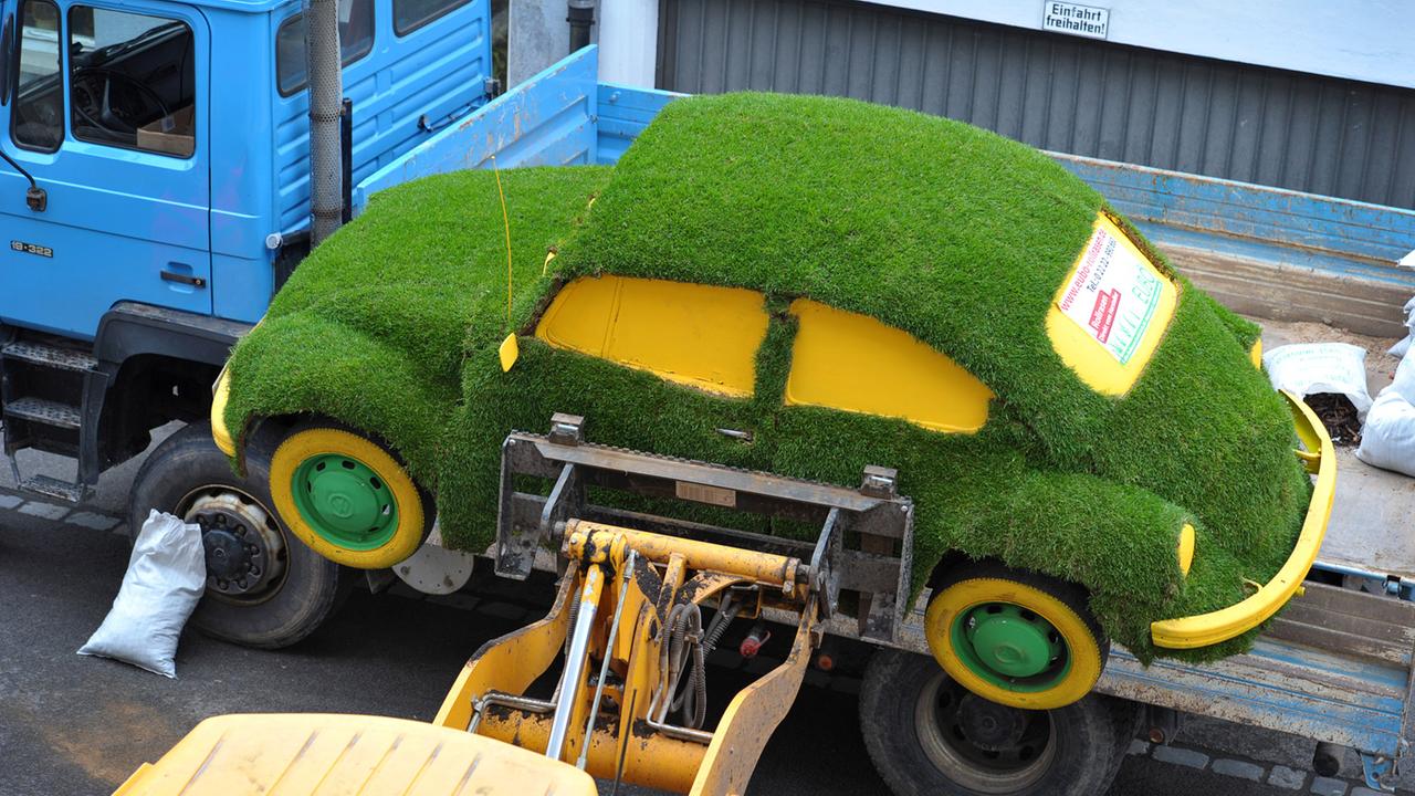 Ein mit Rollrasen überzogener VW Käfer wird für die Gartenmesse in Bamberg abgeladen.