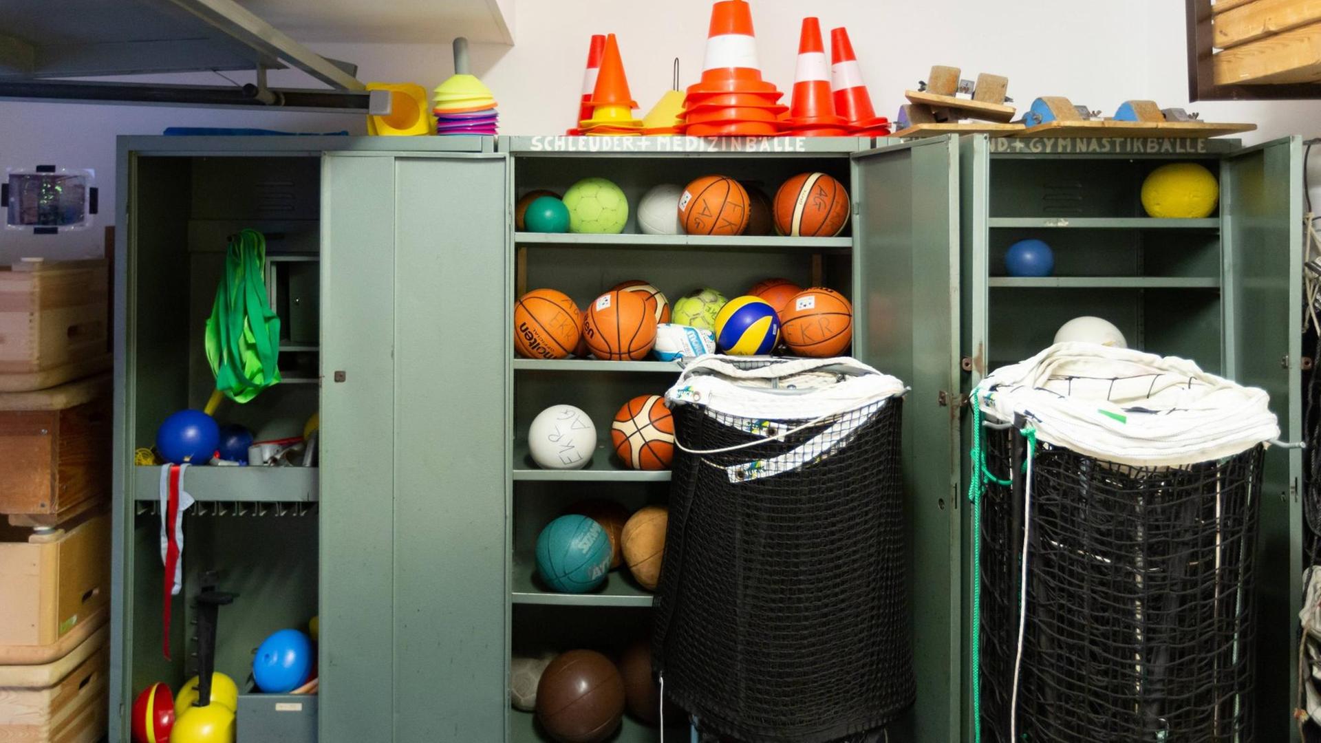 In einem offenen Metall-Schrank liegen Bälle für verschiedene Sport-Arten.