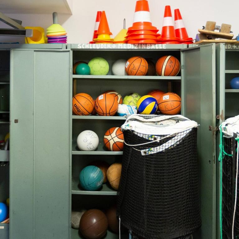 Bälle verschiedener Sportarten in einem Schrank. 