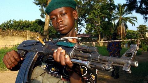 Ein Kinder-Soldat der so genannten Union Kongolesischer Patrioten (UPC) posiert mit einer Waffe in der Hand am 19.6.2003 in Bunia (Kongo). Die zum Volk der Hema gehörende UPC-Miliz verfügte in der Stadt über mehrere hundert Kämpfer, viele von ihnen Kinder. Nach UN-Angaben vom 30.6. überfallen Rebellen in den afrikanischen Bürgerkriegsländern Liberia und Kongo gezielt Schulen und Krankenhäuser, entführen Mädchen und zwingen Jungen zum Kriegsdienst. Dieses Vorgehen der Rebellen verstößt gegen vier Sicherheitsratsresolutionen und andere Bestimmungen des Völkerrechts.