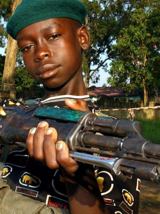 Ein Kinder-Soldat der so genannten Union Kongolesischer Patrioten (UPC) posiert mit einer Waffe in der Hand am 19.6.2003 in Bunia (Kongo). Die zum Volk der Hema gehörende UPC-Miliz verfügte in der Stadt über mehrere hundert Kämpfer, viele von ihnen Kinder. Nach UN-Angaben vom 30.6. überfallen Rebellen in den afrikanischen Bürgerkriegsländern Liberia und Kongo gezielt Schulen und Krankenhäuser, entführen Mädchen und zwingen Jungen zum Kriegsdienst. Dieses Vorgehen der Rebellen verstößt gegen vier Sicherheitsratsresolutionen und andere Bestimmungen des Völkerrechts.
