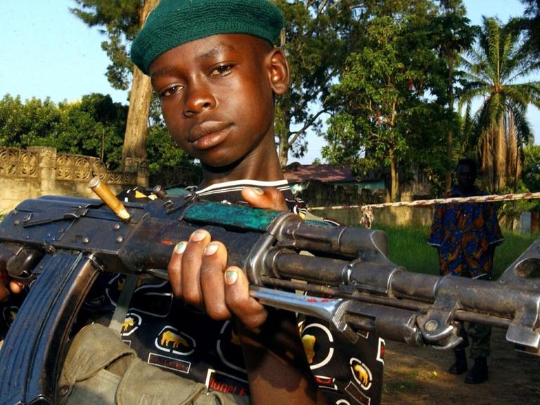 Ein Kinder-Soldat der so genannten Union Kongolesischer Patrioten (UPC) posiert mit einer Waffe in der Hand am 19.6.2003 in Bunia (Kongo). Die zum Volk der Hema gehörende UPC-Miliz verfügte in der Stadt über mehrere hundert Kämpfer, viele von ihnen Kinder. Nach UN-Angaben vom 30.6. überfallen Rebellen in den afrikanischen Bürgerkriegsländern Liberia und Kongo gezielt Schulen und Krankenhäuser, entführen Mädchen und zwingen Jungen zum Kriegsdienst. Dieses Vorgehen der Rebellen verstößt gegen vier Sicherheitsratsresolutionen und andere Bestimmungen des Völkerrechts.