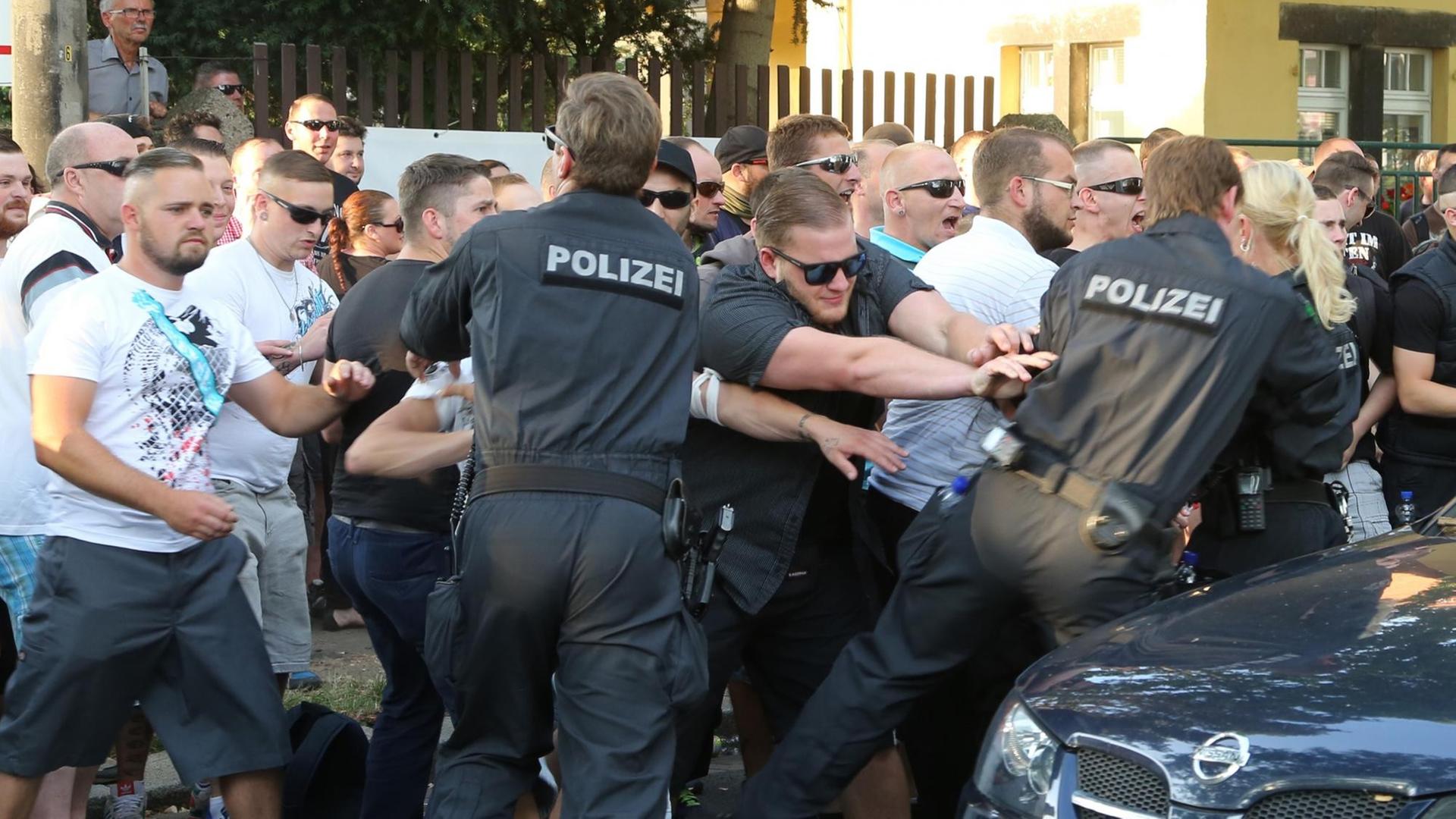 Teilnehmer einer NPD-Demonstration rangeln am 24.07.2015 in Dresden mit Polizeibeamten.