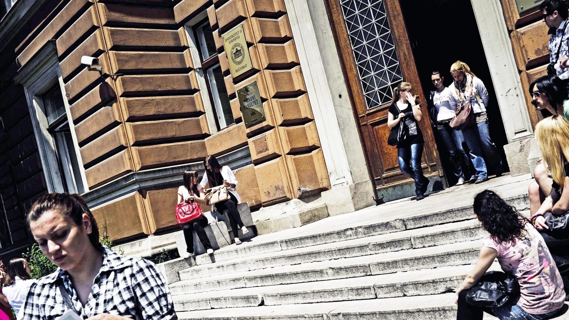 Am Eingang des Rektorats der Hochschule von Sarajevo sitzen Studierende auf den Treppen oder verlassen das Gebäude.