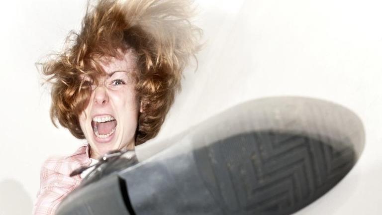 Eine junge Frau auf einer Treppe tritt wütend nach unten.