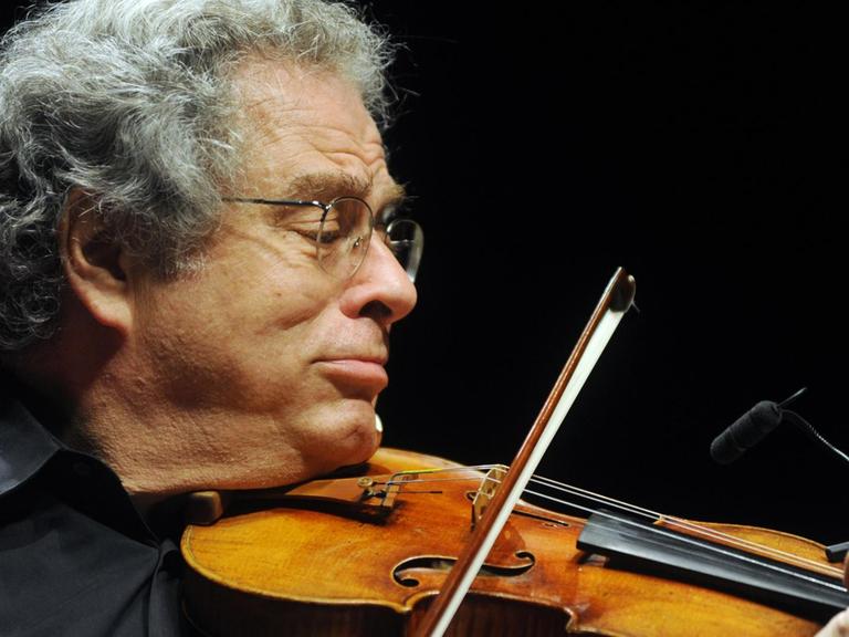 Ein Mann mit grauen Haaren und Brille spielt Violine.