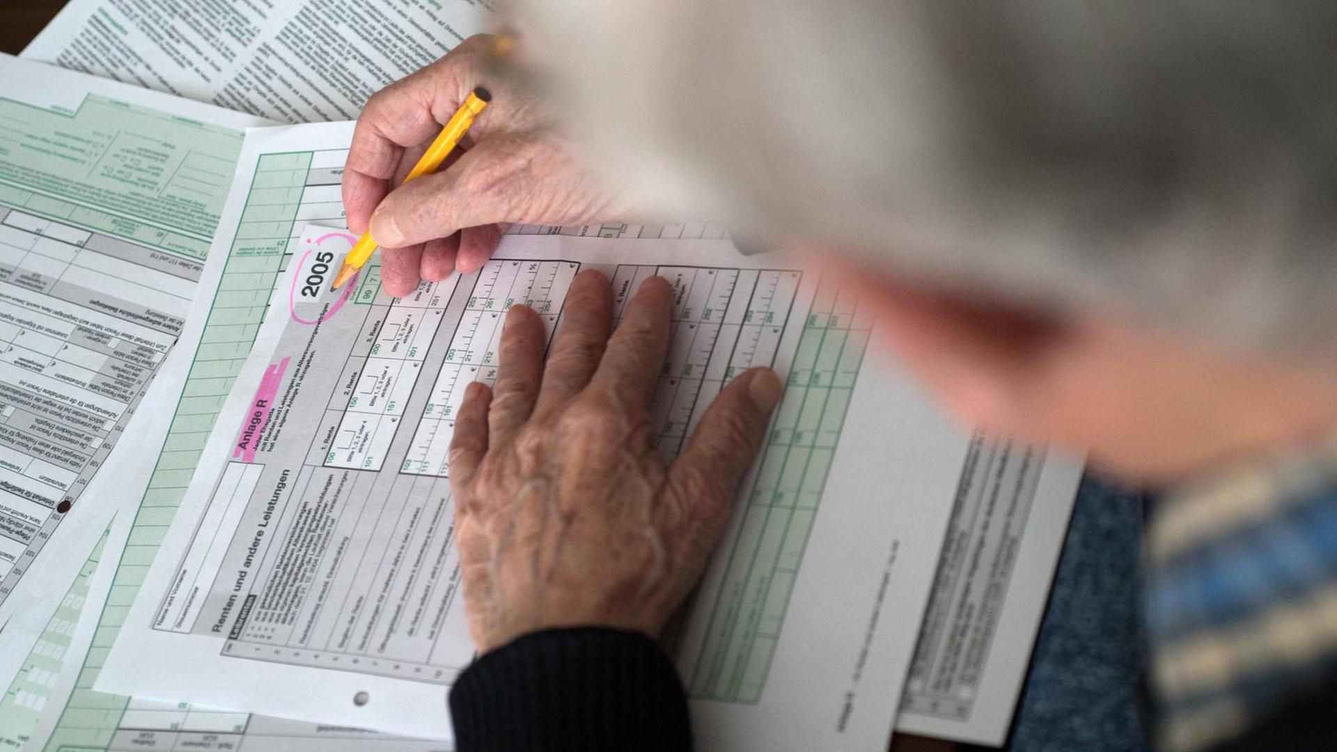 Ein Rentner ist vertieft in das Ausfüllen seiner Einkommensteuererklärung 2005. Für viele Senioren, nicht erst über 80, ist das Ausfüllen der Steuerformulare eine gewaltige Herausforderung.