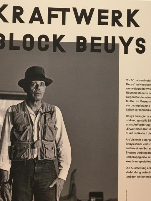 Ein Ausstellungsraum mit einem Plakat von 1970. Es zeigt den Künstler Joseph Beuys.