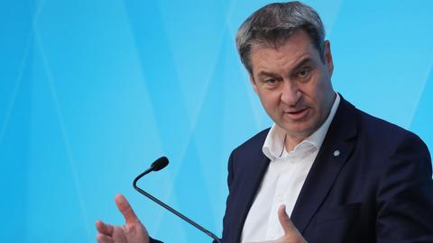 Markus Söder (CSU) steht bei einer Pressekonferenz an einem Pult vor einer blauen Wand.